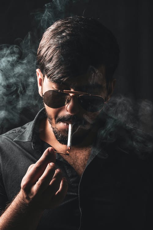 男子吸烟香烟的选择性聚焦摄影 · 免费素材图片