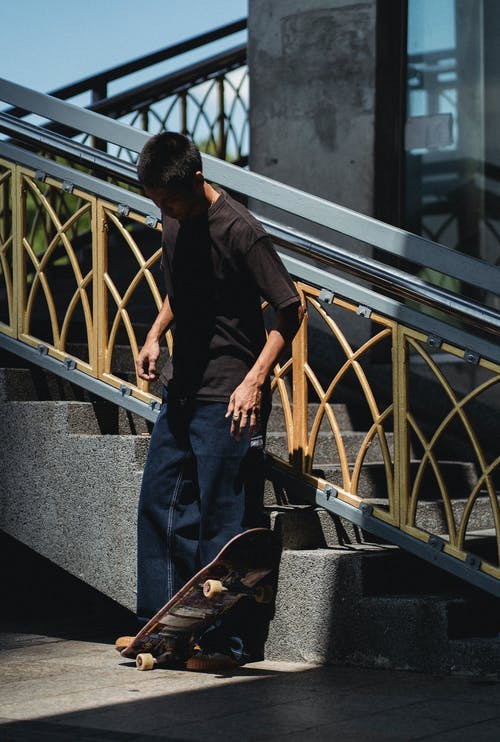 站立与滑板在街道台阶附近的亚裔人 · 免费素材图片