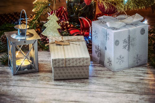 灰色金属灯笼旁边的两个灰色和米色礼品盒 · 免费素材图片