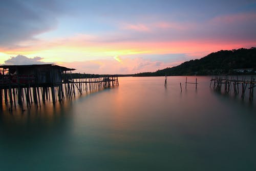 棕色木制码头和海上日落 · 免费素材图片