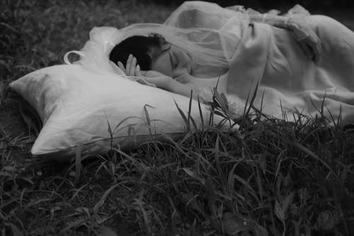 女人躺在草地上的灰度照片 · 免费素材图片