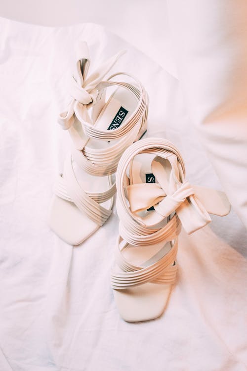 白色纺织品上的白色皮革凉鞋 · 免费素材图片