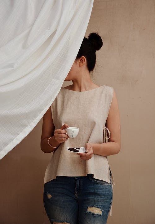 杯咖啡在面料后面的匿名时尚女人 · 免费素材图片