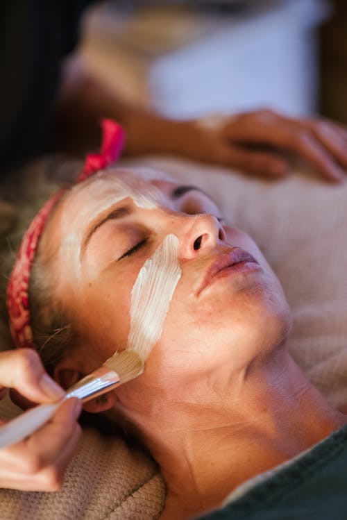 女人戴着面具在水疗中心清洁面部 · 免费素材图片