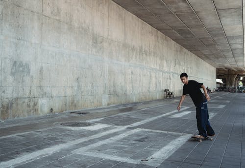 沿铺好的人行道的亚洲人骑马滑板 · 免费素材图片
