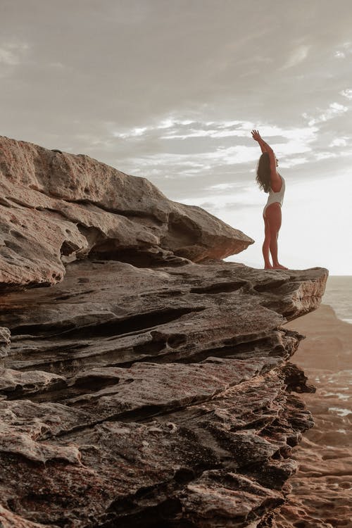 白色泳衣在岩石上的女人 · 免费素材图片