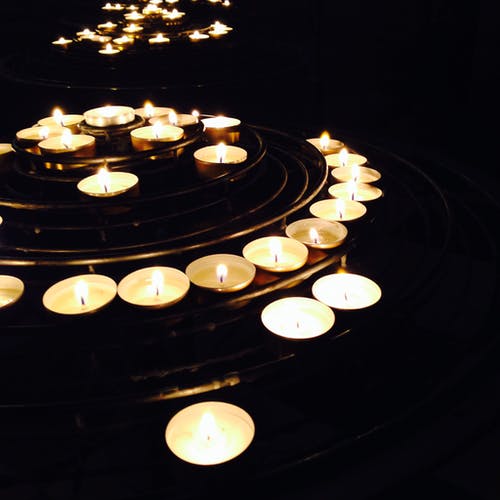 黑色背景上的发光的蜡烛 · 免费素材图片