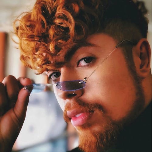 该名男子手持银框太阳镜的特写照片 · 免费素材图片