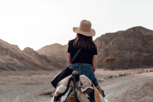 女人在沙漠上骑马匹棕色的马 · 免费素材图片