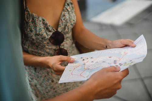 裁剪不露面夫妇检查城市地图上的方向 · 免费素材图片