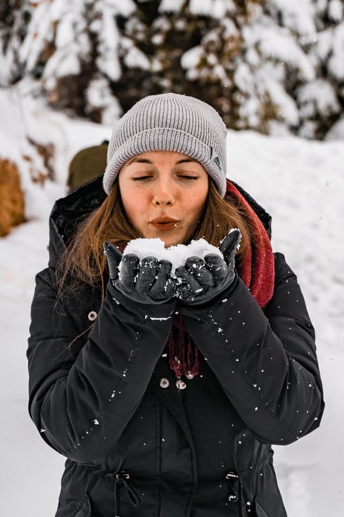 女人从她的手吹雪 · 免费素材图片
