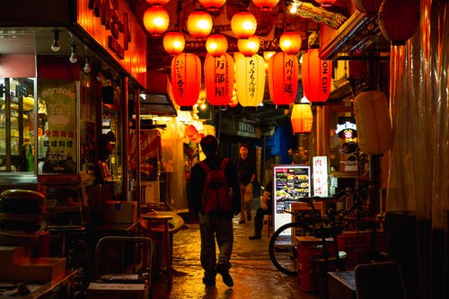 晚上在亚洲食堂之间行走的不可识别的游客 · 免费素材图片