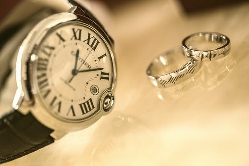 银色圆形模拟手表附近的银色结婚戒指 · 免费素材图片