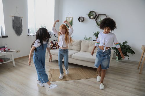 多种族的女孩与匿名朋友在家里的地板上跳舞 · 免费素材图片