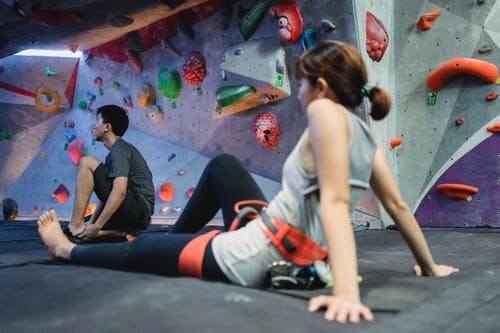 年轻的女人和男人为攀岩训练做准备 · 免费素材图片