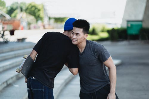 积极的亚洲男人在大街上互相问候 · 免费素材图片