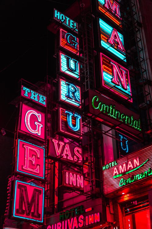 彩色酒店大楼在夜间带领标牌 · 免费素材图片