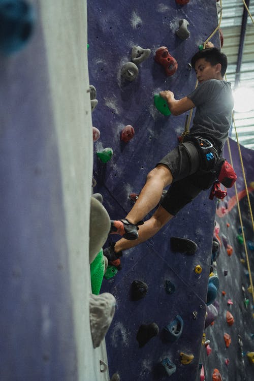 攀岩墙上的年轻运动员 · 免费素材图片