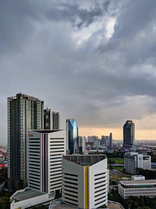 灰色多云的天空下的城市天际线 · 免费素材图片