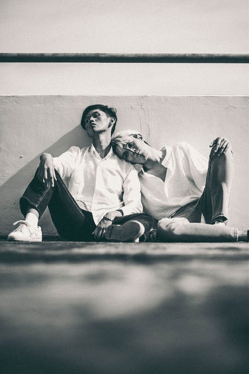 两名男子倚在墙上 · 免费素材图片