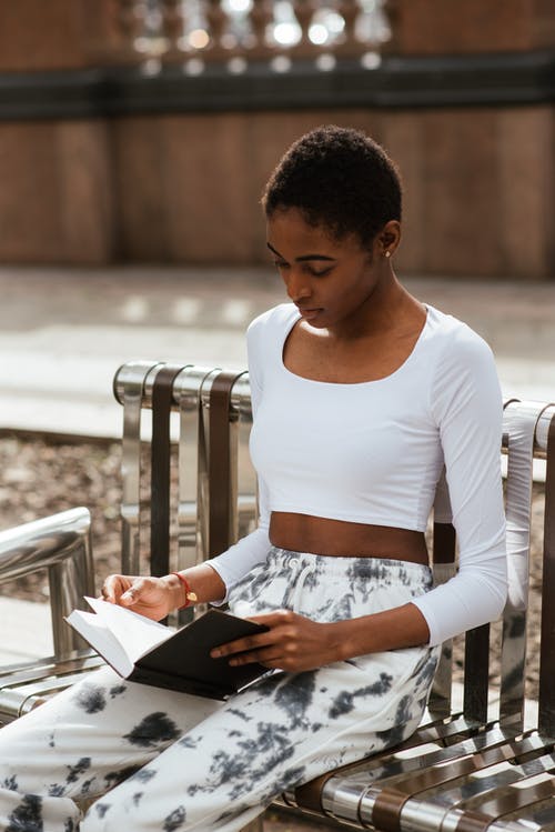在长凳上的沉思黑人女性阅读书 · 免费素材图片