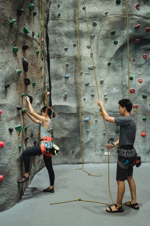 匿名的女人练习与教练攀爬 · 免费素材图片