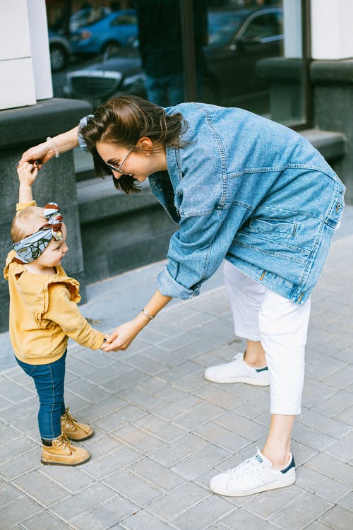 蓝色牛仔夹克和白色的裤子，拿着蓝色裤子的女孩的女人 · 免费素材图片