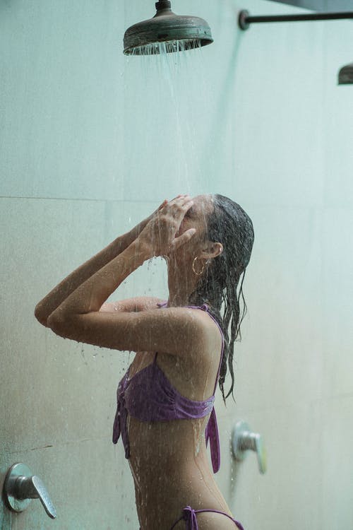比基尼在淋浴下流下的性感女人 · 免费素材图片