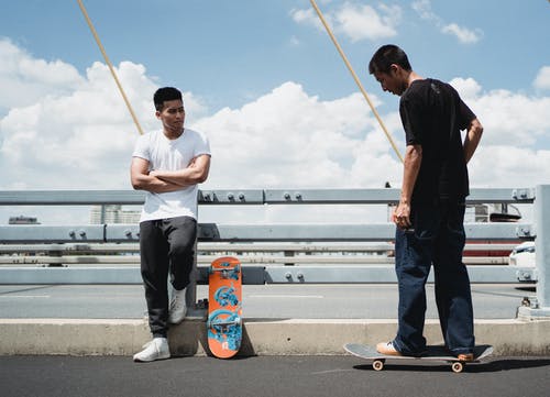 夏天在城市桥梁上的亚洲滑板手 · 免费素材图片