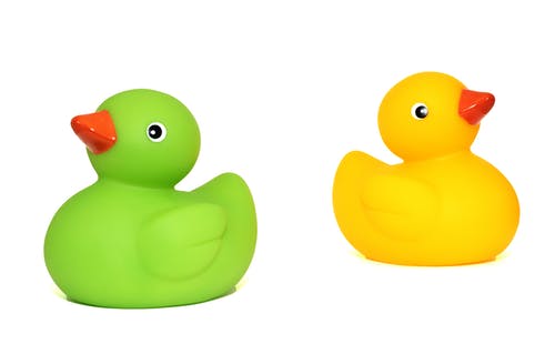 绿鸭玩具旁边的黄鸭玩具 · 免费素材图片