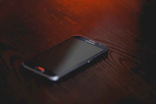 棕色木质表面的黑色三星智能手机 · 免费素材图片