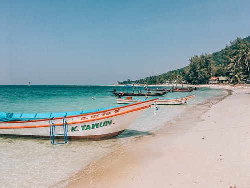 白色和蓝色的小船，在海滩上 · 免费素材图片