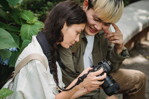 使用照片照相机的快乐的亚洲夫妇在公园 · 免费素材图片