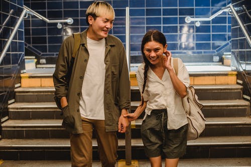 性格开朗的亚洲夫妻在地下走廊的台阶上行走 · 免费素材图片