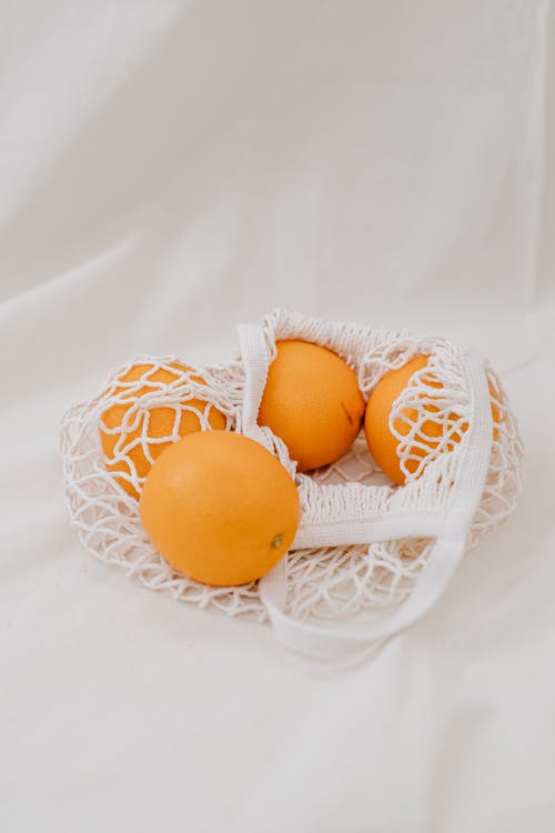 白网中的四个黄橙鸡蛋 · 免费素材图片