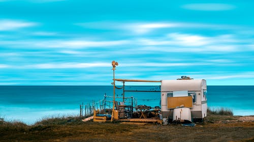海滩岸上的白色和棕色露营车 · 免费素材图片