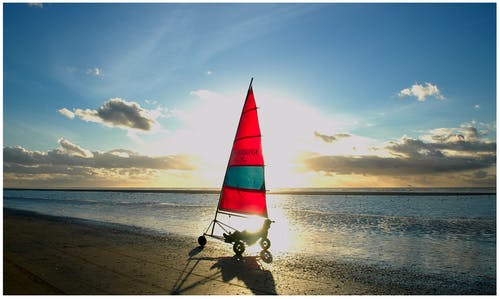 男子在沙滩上骑帆船 · 免费素材图片