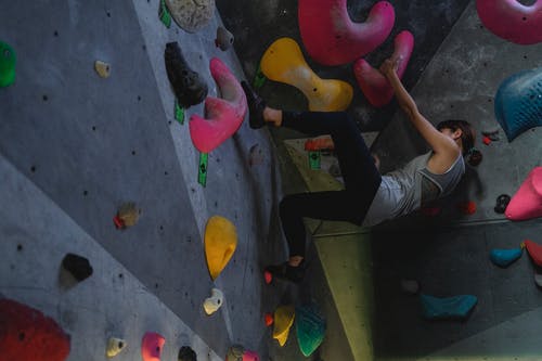 在体育馆里强大的巨石训练期间的坚强登山者 · 免费素材图片