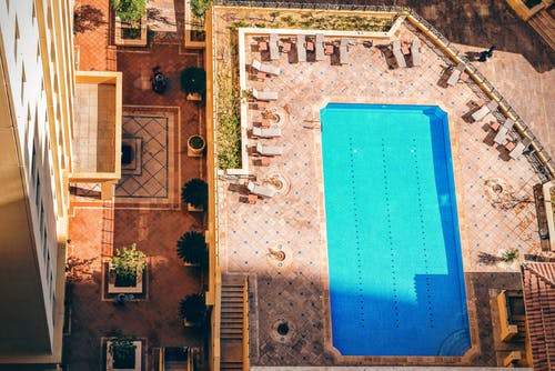 高层大楼附近的矩形泳池，白天 · 免费素材图片