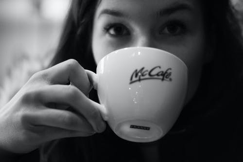 女人喝咖啡的灰度摄影 · 免费素材图片