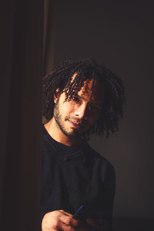 黑船员的脖子衬衫，拿着他的电话的人 · 免费素材图片