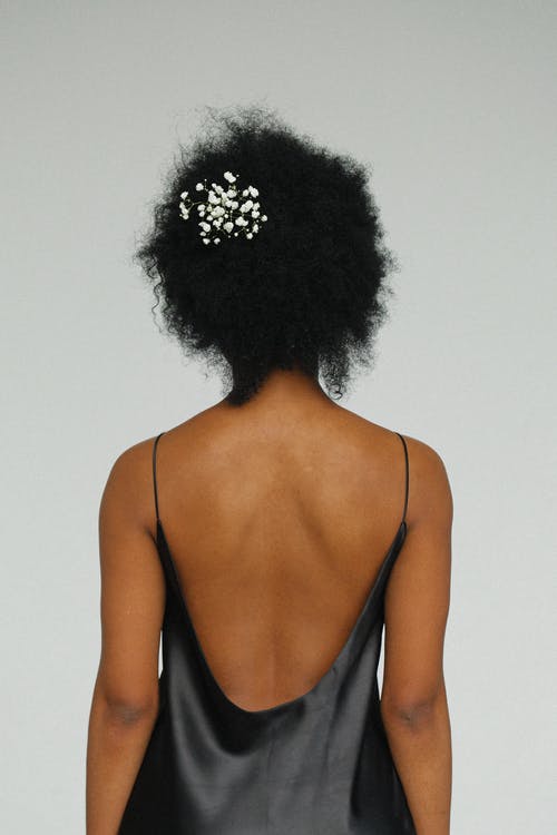 女人穿着黑色晚礼服站在灰色背景前的背影照片 · 免费素材图片