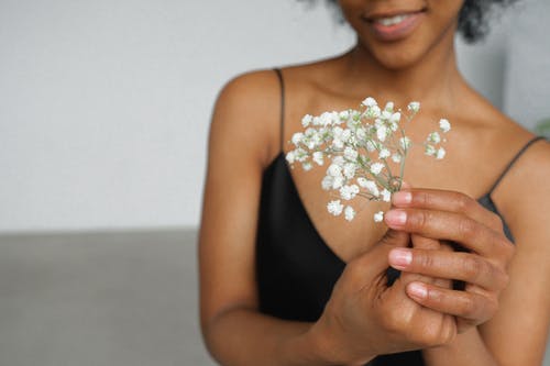 黑色意粉顶部的女人，她手里的白花 · 免费素材图片