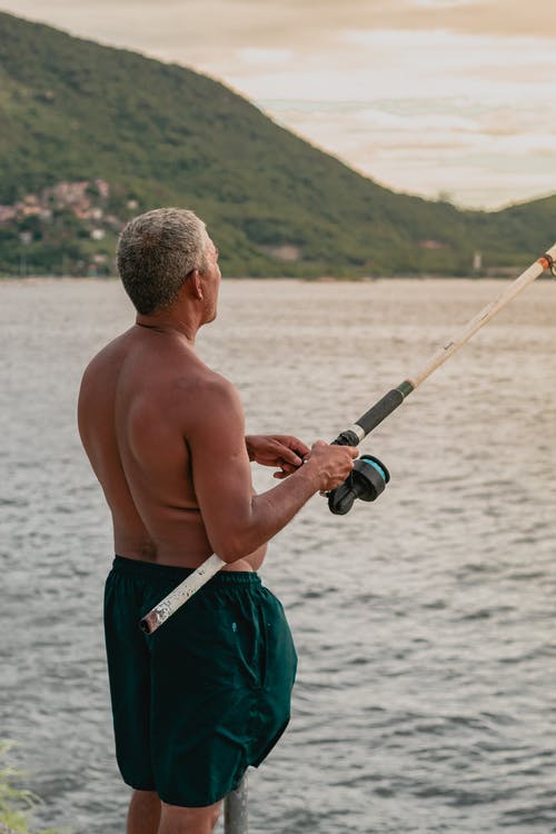 男子手持钓鱼竿 · 免费素材图片