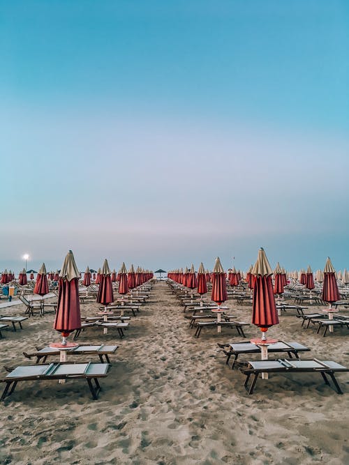 海滩上的红色和白色的伞 · 免费素材图片