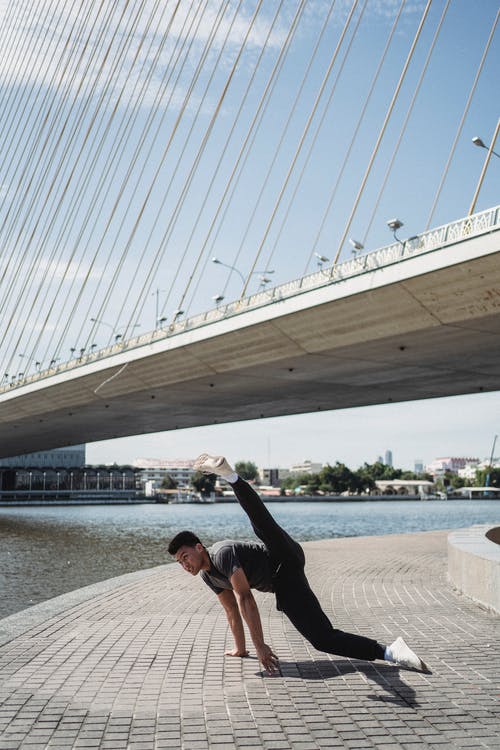 运动型的亚洲人，在城市河畔表演霹雳舞 · 免费素材图片