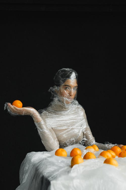 拿着橙色水果的白色长袖衬衫的女人 · 免费素材图片
