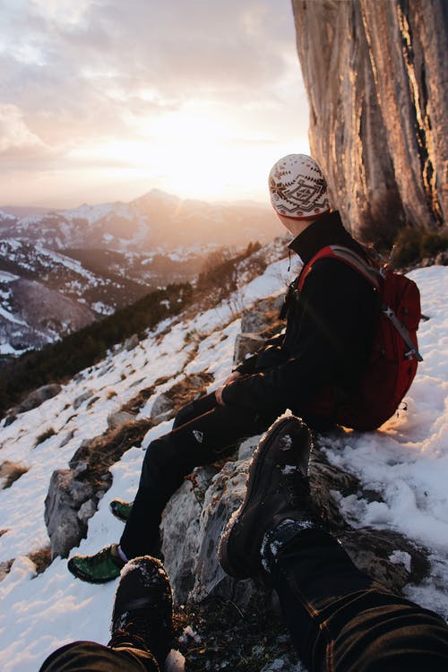 坐在雪山的人的选择性聚焦摄影 · 免费素材图片