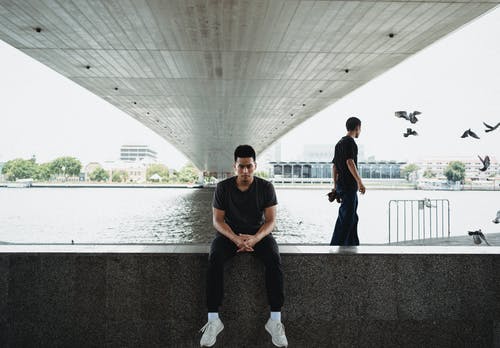 亚洲男子坐在路堤在桥下 · 免费素材图片