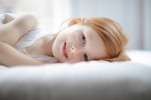 躺在床上的白色背心的女孩 · 免费素材图片